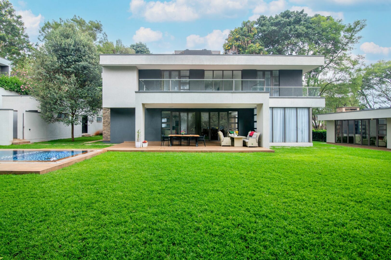 Open-plan living and dining area in luxury Karen residence with floor-to-ceiling glazing