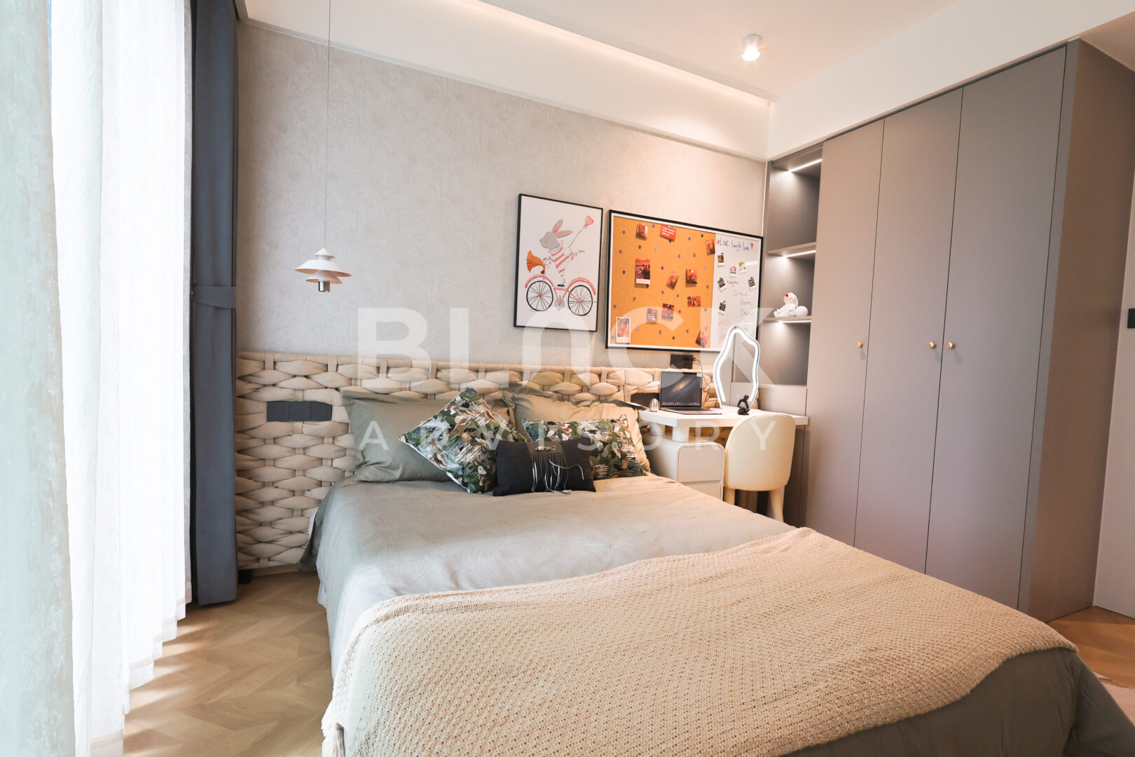 Amani Residence show apartment bedroom with a double bed and framed prints above a desk
