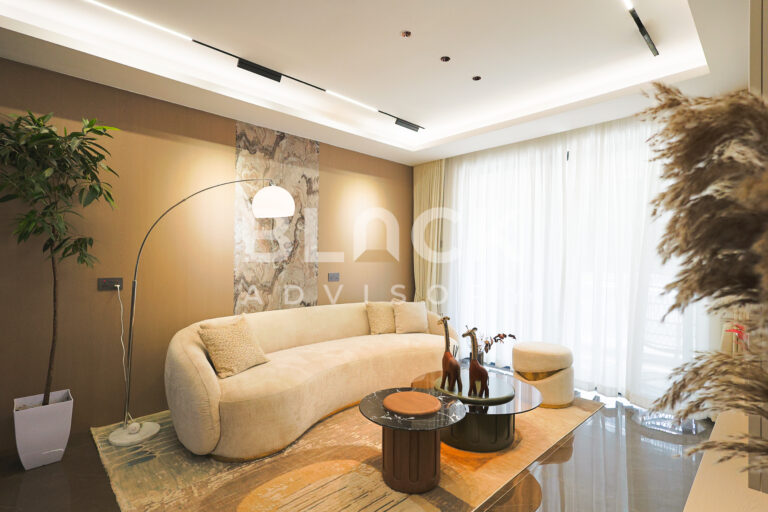 ATREUS Brookside show apartment living room with a curved sofa, an arc floor lamp and sheer curtains